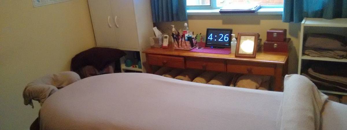 A photo of the massage room showing the table and towels